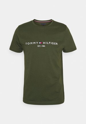 Oliwkowa koszulka z krótkim rękawem i okrągłym dekoltem z napisem „Tommy Hilfiger EST. 1985” oraz małym czerwono-biało-niebieskim logo na piersi.