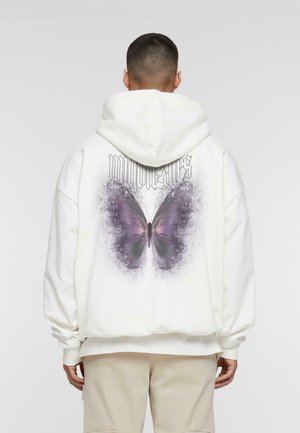 White hoodie with a large purple butterfly graphic on the back, featuring black text above and loose, comfortable fit. Textured fabric.