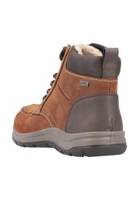 Bota de tobillo de cuero marrón con acentos grises, diseño con cordones, forro de piel de oveja, exterior texturizado y suela de goma para tracción.