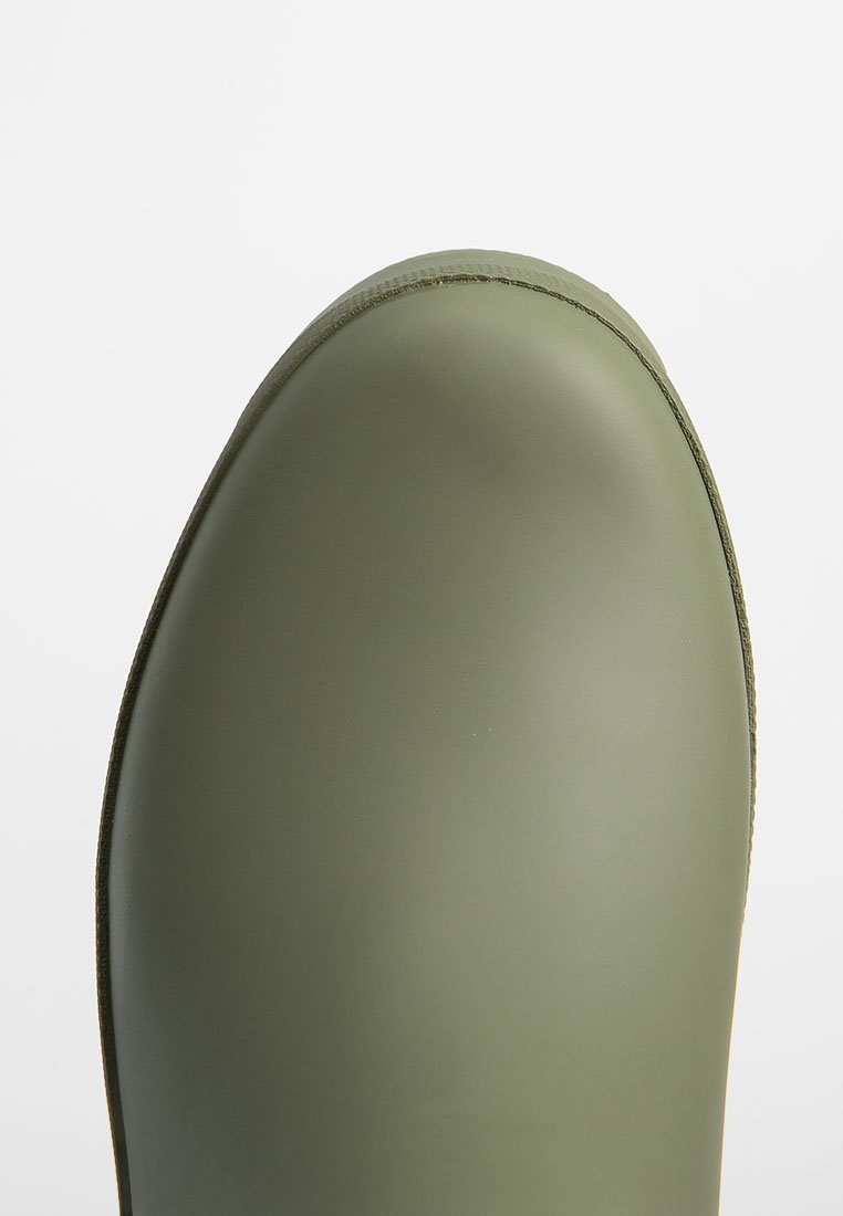 Punta de bota de goma verde oliva suave con forma redondeada y borde cosido, presentada sobre un fondo blanco liso.