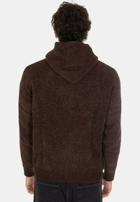 Maglione cappuccio marrone con lavorazione a maglia testurizzata. Presenta polsini e orlo a costine. Vista da dietro, che mostra il cappuccio e la vestibilità rilassata.
