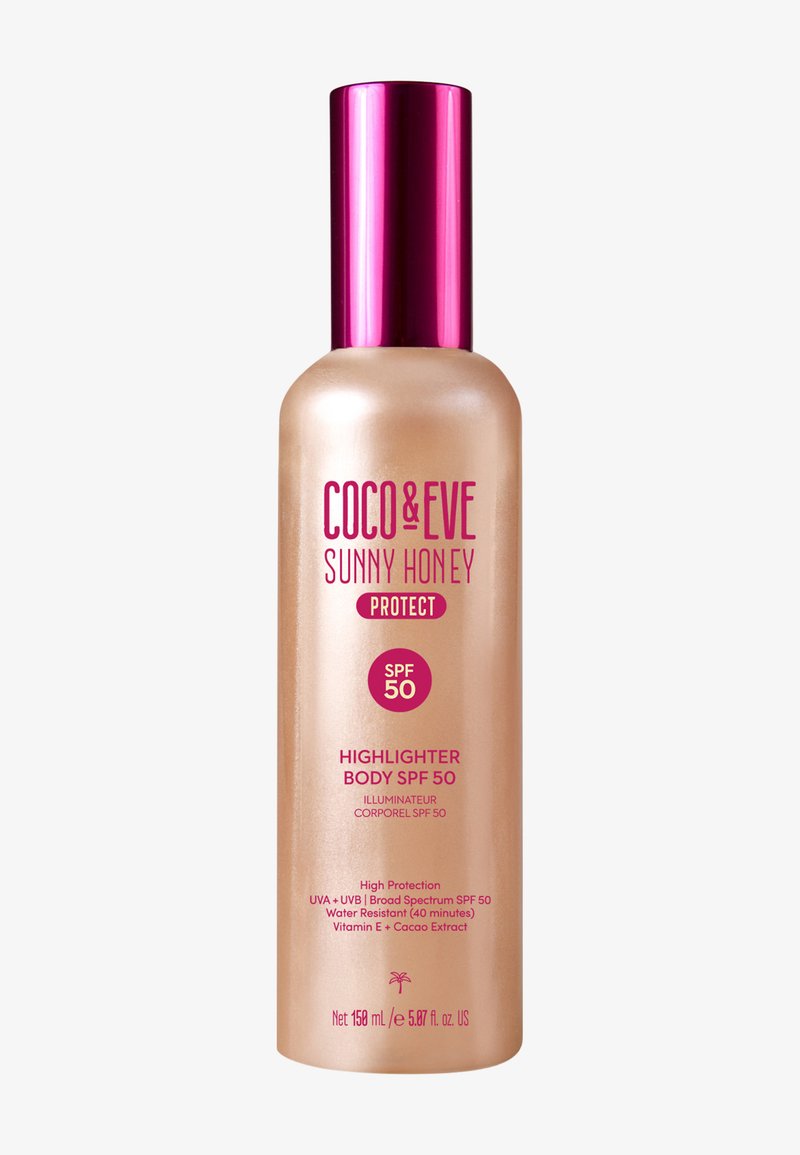 Coco & Eve Sunny Honey Highlighter Body SPF 50 w złotym opakowaniu z różową nakrętką; oznaczony informacjami o ochronie przeciwsłonecznej i składnikach.