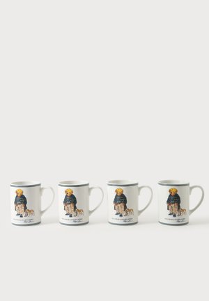 Quatre tasses en céramique blanche avec anse, chacune présentant un ours portant une veste et un pantalon à côté d'une illustration d'un petit chien.
