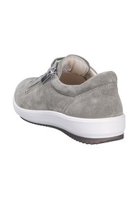 Šedá semišová teniska s bílou gumovou podrážkou, vybavená bočním zipem a polstrovaným límcem pro pohodlí. Hladká textura a zaoblený tvar.