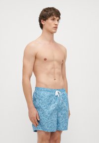 Heledad sinise värvi ujumispüksid, millel on tekstuuriga lillemuster, elastne vöökoht ja valge nöör. Kujundatud mugavale istumisele.