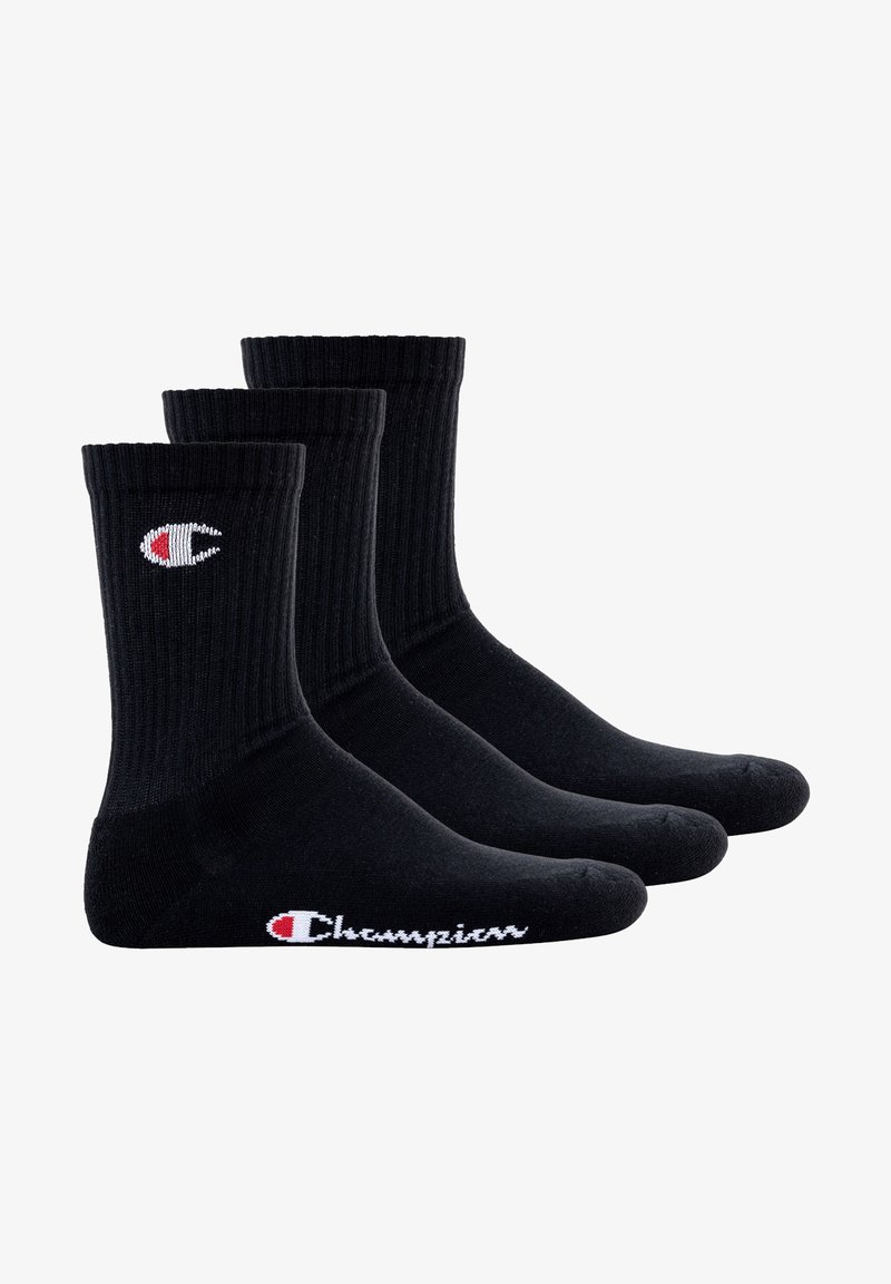 Black cotton crew socks with ribbed texture, featuring a white and red Champion logo on the side. Pack of three pairs.