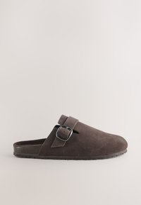 Sabot en daim marron à enfiler avec bride réglable à boucle et semelle en caoutchouc texturée, présenté en vue de profil sur fond neutre.