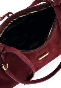 Bordowa torebka zamszowa z zamkiem i elementami w kolorze złotym. Wnętrze wyłożone czarną podszewką z wzorem logo marki oraz wieloma kieszeniami.
