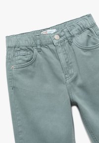 Spodnie o luźnym kroju w miękkim, stonowanym odcieniu teal z matowym wykończeniem. Posiadają przednie kieszenie i metalowy guzik zapięcia.