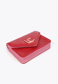 Röd läderplånbok med en rosa insida, med en sned flik och logotyp i guld på framsidan. Slät textur med en blank yta.