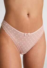 Roze kanten string met hartjespatroon van gaas, fijne kanten rand en een klein satijnen strikje aan de voorkant. Zacht, rekbaar materiaal met een gladde afwerking.