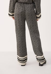 Zwart-witte visgraatpatroon wijde broek met een contrasterende gestreepte zoom. Elastische tailleband en soepele, textuurstof.