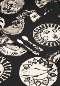 Schwarzer Stoff mit handgezeichnetem, weißen Geschirr und Besteck. Die Designs umfassen Teller, Fische und florale Motive mit variierenden Linienstilen.