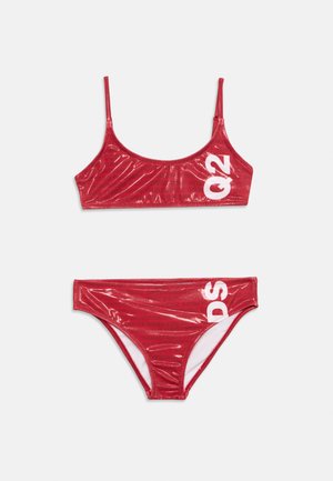 Raudonas blizgus bikini komplektas su baltais blokiniais užrašais "Q2" viršuje ir "DS" apačioje, su plonomis petnešėlėmis ir blizgiu paviršiumi.