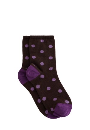 Chaussettes marron foncé à pois violets avec talons et orteils violets unis, posées à plat sur un fond blanc.