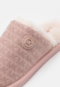 Chausson rose doux à enfiler avec doublure en fausse fourrure et dessus en tissu texturé avec un badge logo circulaire Michael Kors.