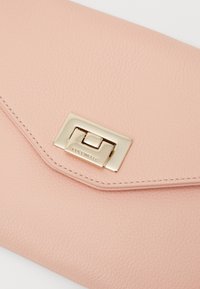 Clutch in pelle rosa cipria con finitura texturizzata, caratterizzato da una chiusura in metallo dorato e cuciture sottili lungo i bordi.