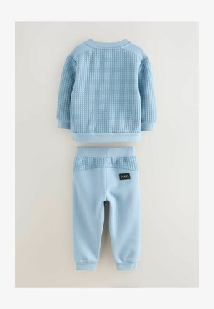 Set de jogging pentru copii de culoare albastru deschis, compus dintr-un hanorac texturat și pantaloni asortați, ambele având accente ribbate și manșete elastice.