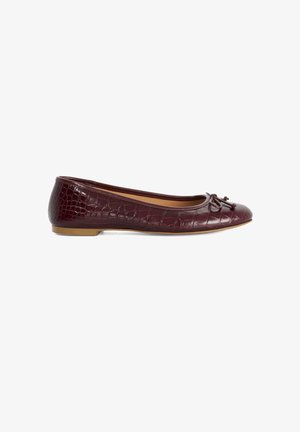 Ballerine plate bordeaux en cuir embossé croco, bout arrondi, petit nœud et semelle marron clair.