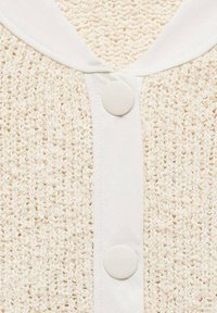 Jasny beżowy kardigan z teksturowanym wzorem dzianiny. Posiada biały kołnierz i dwa duże, okrągłe guziki z przodu.