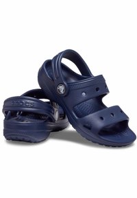 Námořnické modré Crocs sandály vyrobené z lehkého materiálu; otevřený design s několika ventilačními otvory a nastavitelné popruhy pro pohodlné nošení.