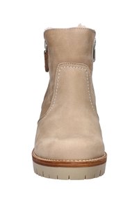 Beige enkelboot van suede, met een ronde neus, contrasterende stiksels en een lage rubberen zool met een duidelijk loopvlak.