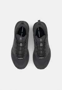 Zwarte sportieve schoenen met een ademende bovenkant van mesh, versterkte details en een gestructureerde zool. Beschikt over veterloze veters en een trekhaak aan de hiel.