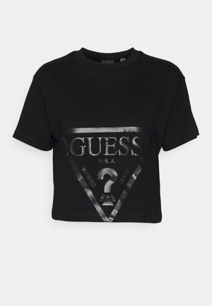 Czarna krótka koszulka z bawełny z błyszczącym trójkątnym logo z napisem "GUESS", "U.S.A." oraz "WASHED JEANS" w kolorze srebrnym.