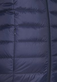 Chaqueta de plumas azul marino con costuras horizontales, cierre de cremallera y un pequeño bolsillo con cremallera en el lado izquierdo para mayor funcionalidad.