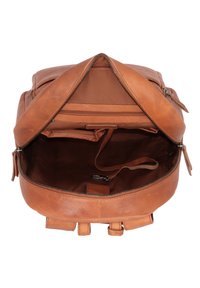 Mochila de cuero marrón con cierre en la parte superior, interior espacioso y un pequeño bolsillo interior. Cuenta con correas ajustables y una textura suave.