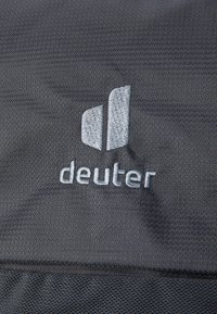 Gray fabric with a textured finish featuring the word "deuter" embroidered in light gray, accompanied by a logo with two overlapping shapes.