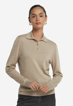 Beige långärmad polo med krage, tre knappar i placket och ribbad nederkant och ärmslut. Mjuk textur, figurformad design, minimalistisk stil.