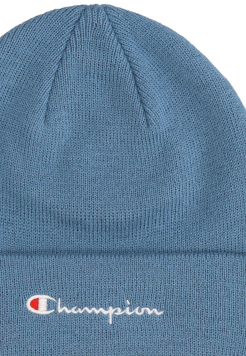 Blaue gestrickte Beanie mit einem gerippten Design. Verfügt über ein gesticktes „Champion“-Logo in Weiß und Rot am umgeschlagenen Rand. Weicher Stoff.