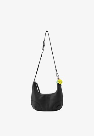 Sac à bandoulière en cuir noir avec un design incurvé, une sangle réglable et un pendentif smiley jaune avec un accent de pompon menthe.