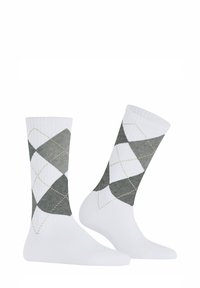 Weiße Baumwollsocken mit einem grünen Argyle-Muster, hellgrauen Rauten und goldenen Nähten. Glatte Textur, knielanges Design.
