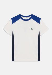 T-shirt blanc à manches courtes avec des panneaux d'épaule bleu foncé, un col rond et un petit logo de crocodile vert sur la poitrine.