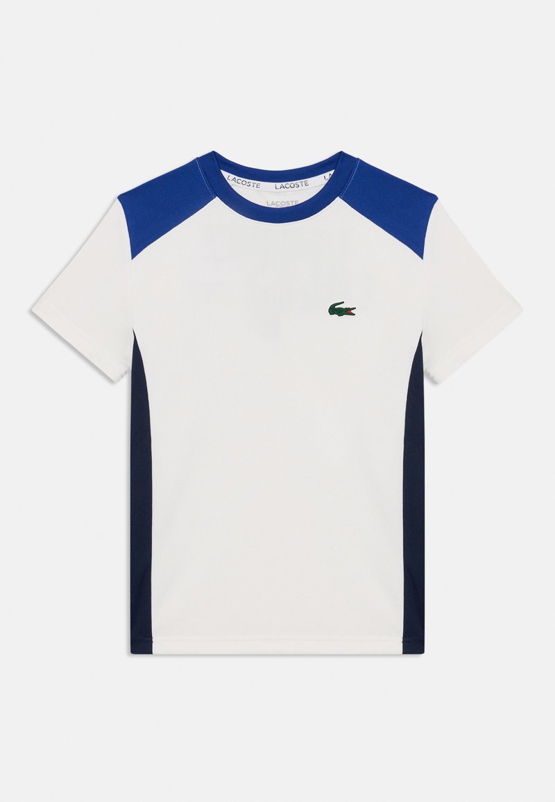 T-shirt blanc à manches courtes avec des panneaux d'épaule bleu foncé, un col rond et un petit logo de crocodile vert sur la poitrine.