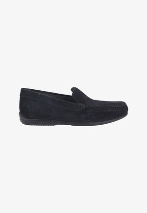 Mocassin pour homme en daim noir à enfiler, avec des détails cousus et une semelle en caoutchouc, présenté de profil sur un fond blanc.