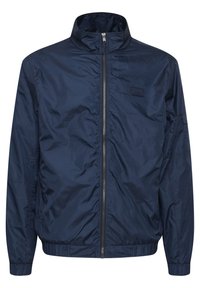 Marineblauwe lichtgewicht jas met hoge kraag, volledige rits, elastische manchetten en zoom. Gemaakt van glad, waterafstotend materiaal.