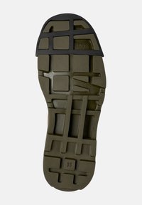Suola di scarpa in gomma di colore verde oliva con una superficie testurizzata, caratterizzata da un motivo a rete e dettagli neri. La taglia 38 è indicata sulla suola.