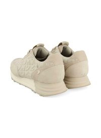 Scarpe da corsa beige con tomaia in suede testurizzato, suola intermedia ammortizzata e design minimalista. Presentano un'etichetta per il trasporto e un dettaglio distintivo sul tallone.