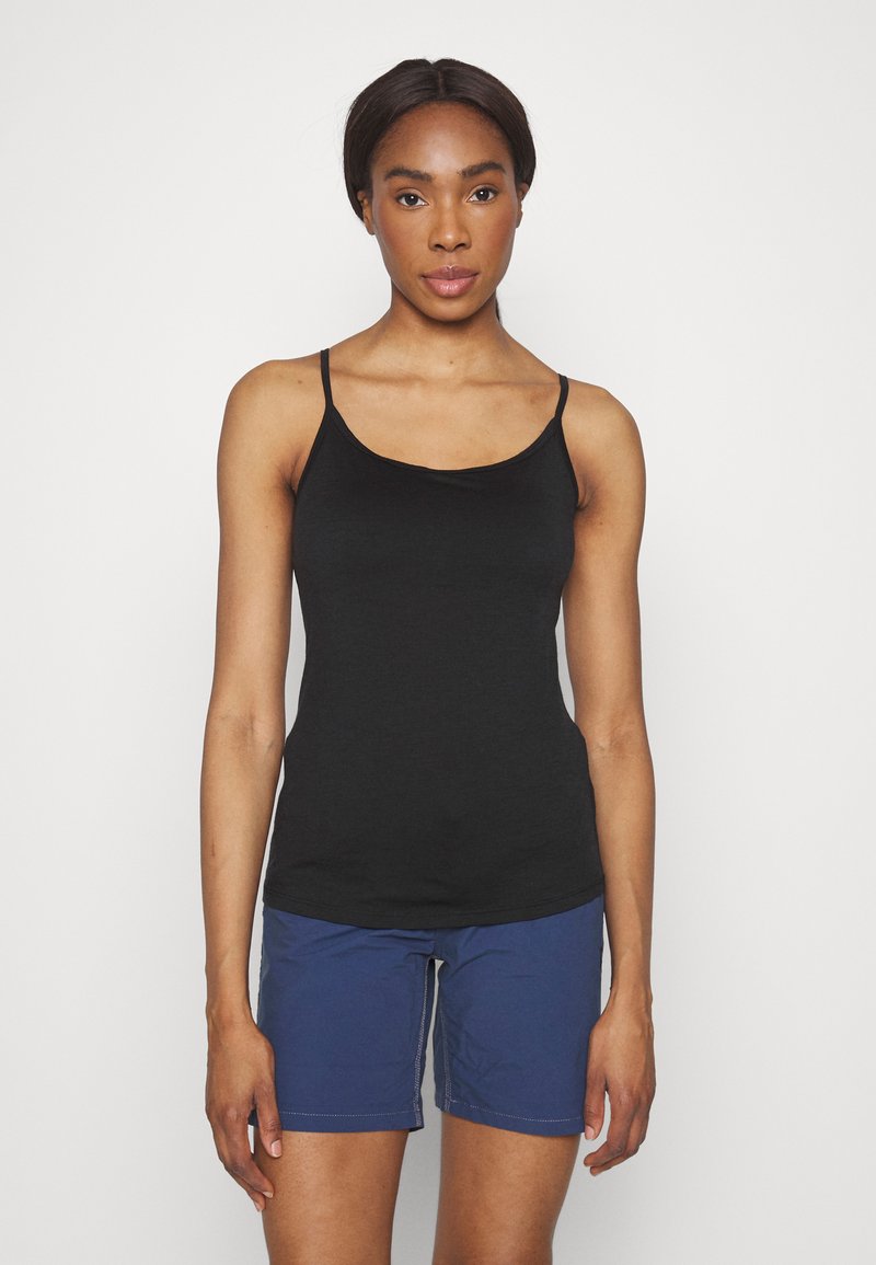 Svart ärmlös linne med tunna axelband, tillverkat av slät tyg. I kombination med blå shorts med synlig sömnad och sidofickor.