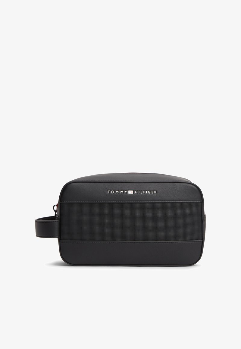 Μαύρη ορθογώνια τσαντούλα καλλυντικών με πλαϊνή λαβή, υφή στην μπροστινή όψη και λογότυπο "Tommy Hilfiger" σε λευκό και κόκκινο στην επάνω μπροστινή πλευρά.