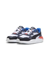 Sneakers Puma con una tomaia in rete bianca, accenti in pelle blu scuro, dettagli rossi e blu, e una suola in gomma bianca con pattern testurizzati.