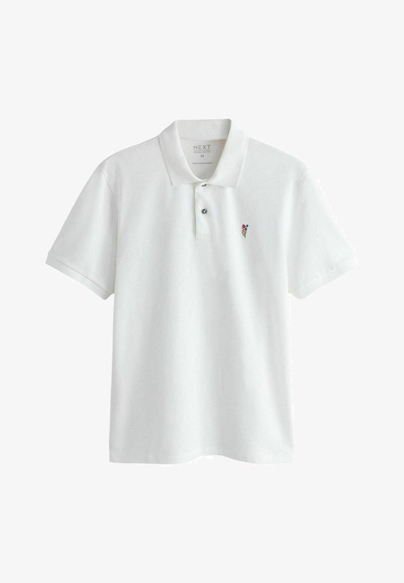 Witte polo met korte mouwen, een kraag, twee knopen en een kleine geborduurde meerkleurige bloem op de linkerborst.