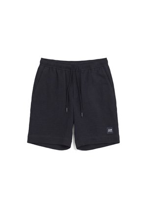 Pantaloncini casual neri con vita elasticizzata e coulisse, tasche laterali e una piccola patch quadrata con logo sulla parte inferiore della gamba sinistra.