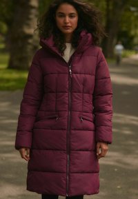 Bordeaux péřová bunda s kapucí, prošívaný design, přední zip a dvě boční kapsy. Má nastavitelné šňůrky a střední délku.