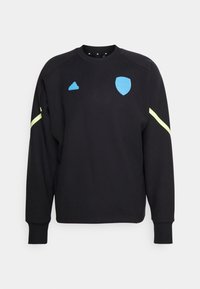 Felpa nera realizzata in tessuto morbido con collo a giro, caratterizzata da un logo e uno scudo Adidas blu e dettagli in neon giallo sulle maniche.
