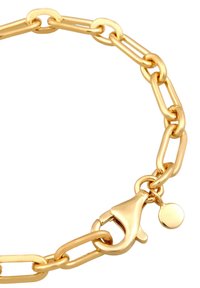 Aranyszínű fémből készült lánc karkötő, hosszúkás láncszemekből. Lobster zár és egy kis kör alapú charm függő díszíti. Simaság, csillogó felület jellemzi.
