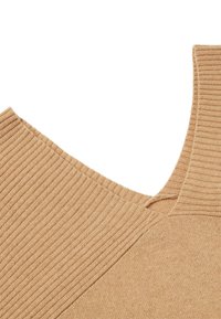 Maglione beige lavorato a maglia con texture a costine, caratterizzato da una scollatura ampia e dettagli di cuciture diagonali. Materiale morbido; nessun motivo visibile o hardware.
